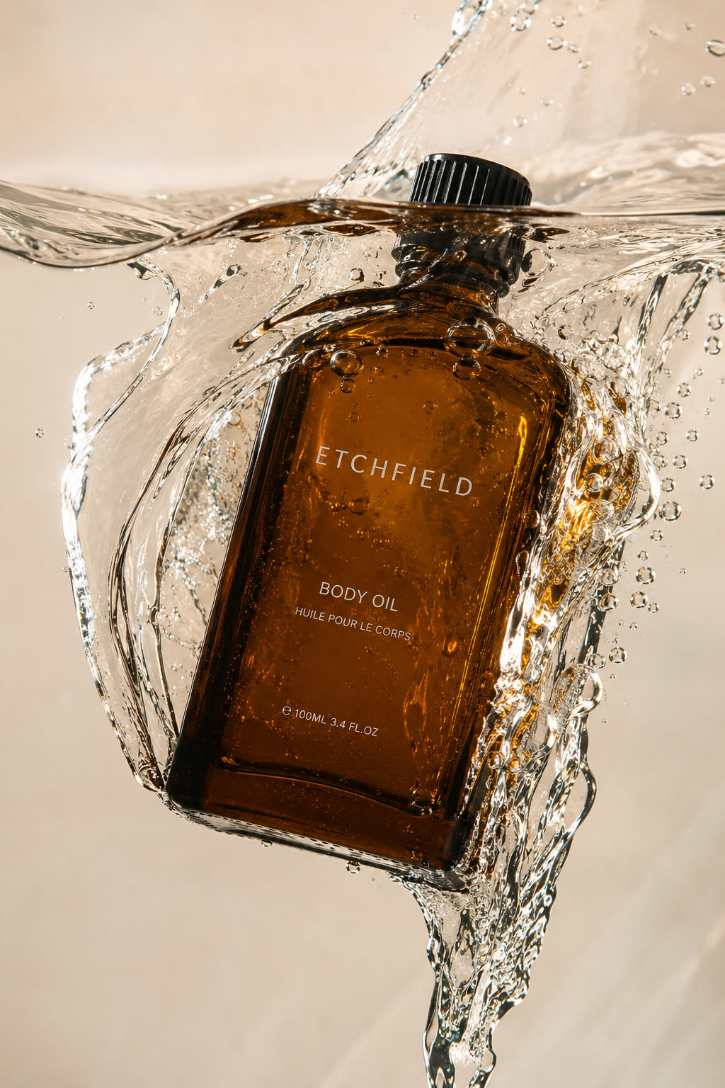 An amber glass bottle labelled Etchfield Body Oil, photographed mid water splash