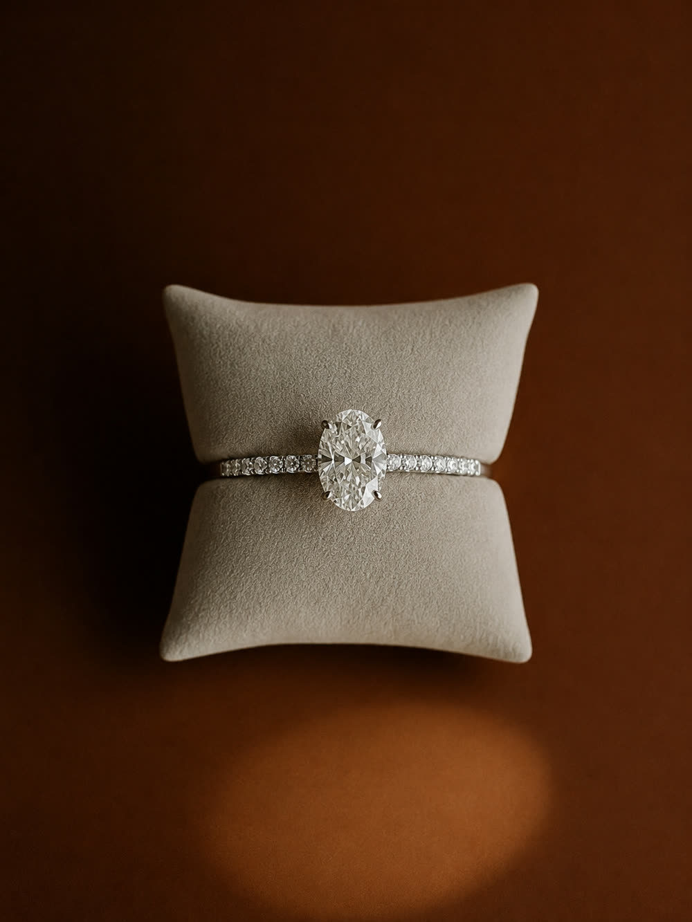 A diamond halo ring produced on a pale cushion, the stone's warm tone and setting held exactly