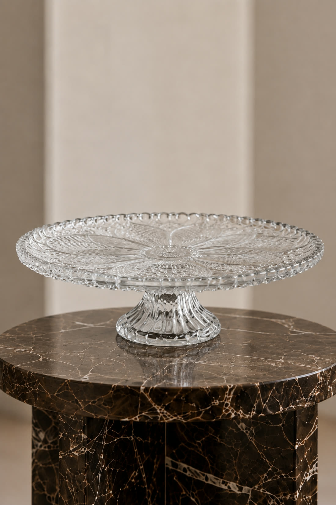 The same cut glass footed stand produced empty on a dark marble side table