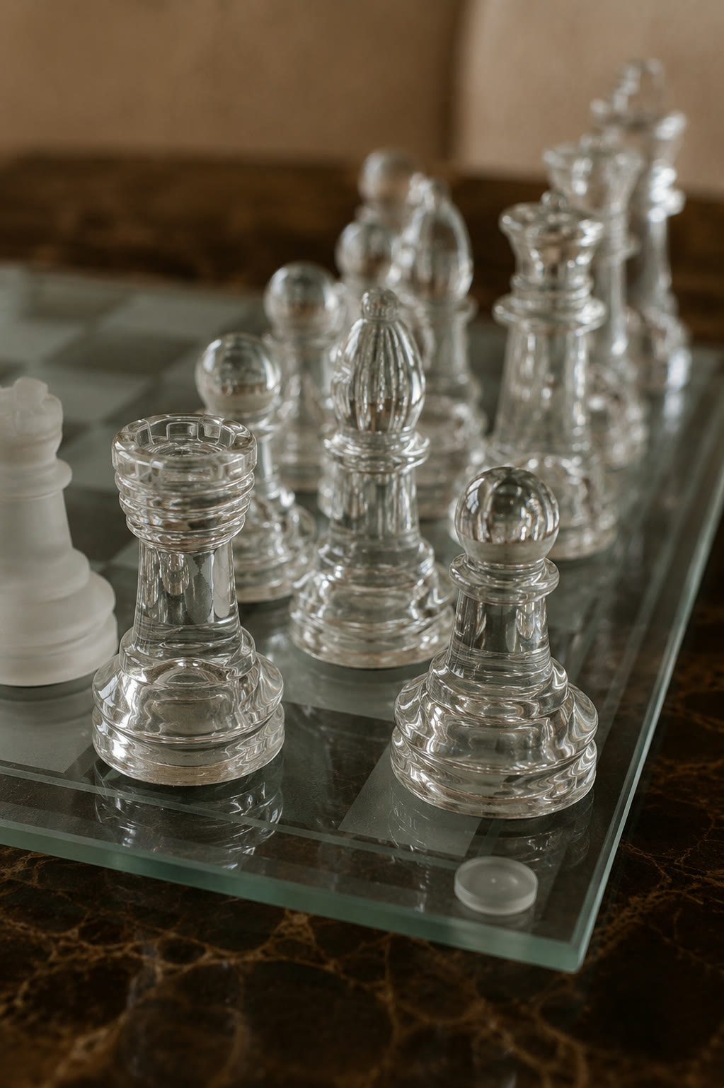 Detail of the frosted glass chess pieces, a rook, bishop and pawns, on the glass board